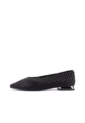 Zapato plano negro tejido con textura, tacón metálico bajo de forma geométrica, puntera puntiaguda y estilo sin cordones, mostrado de lado sobre fondo blanco.