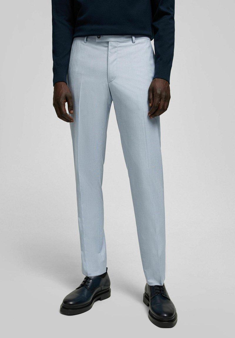 Hellblaue Anzughosen mit geradem Beinschnitt, aus strukturiertem Stoff gefertigt, kombiniert mit schwarzen Leder-Schnürschuhen.