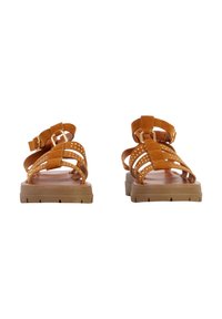 Sandales en daim marron avec plusieurs brides, boucles dorées et semelles épaisses en caoutchouc, vues de face sur un fond blanc.