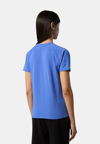 T-shirt azzurro chiaro a maniche corte con scollo rotondo e dettagli sottili sulle spalle. Tessuto morbido e vestibilità rilassata, progettato per il comfort.