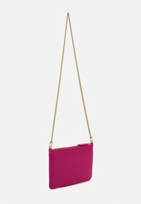 Karsti rozā mākslīgās ādas crossbody soma ar zelta ķēdes siksnu, rāvējslēdzēja aizdari un mazu atloku akcentu. Gluda tekstūra, taisnstūra forma.