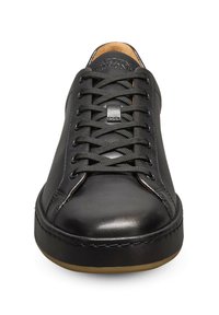 Sneaker en cuir noir avec bout arrondi, surface texturée et lacets plats. Présente une semelle en gomme de couleur contrastante et un branding discret sur la languette.