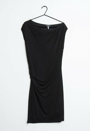 Schwarzes, knielanges Kleid mit kurzen Ärmeln und drapiertem Detail auf einem Bügel vor weißem Hintergrund.