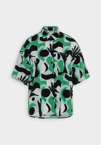 Chemise à manches courtes avec un motif abstrait audacieux en vert, noir et blanc. Fabriquée en tissu léger avec une coupe décontractée.
