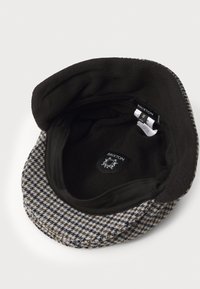 Uldhætte med et hundetand mønster i grå og brun med sort fleeceforing. Indeholder mærkat indeni. Flad skygge design.
