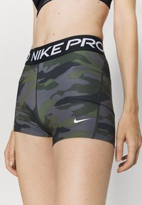 Nike Pro camouflage shorts met een zwarte tailleband met de tekst "PRO" en een klein wit logo. Gemaakt van rekbaar, aansluitend materiaal.
