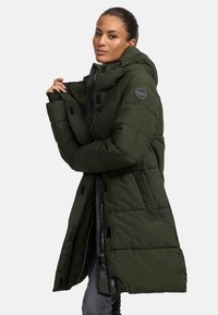 Long, olive green puffer coat with a hood, featuring zippers, a round logo patch on the sleeve, and horizontal stitching for texture.