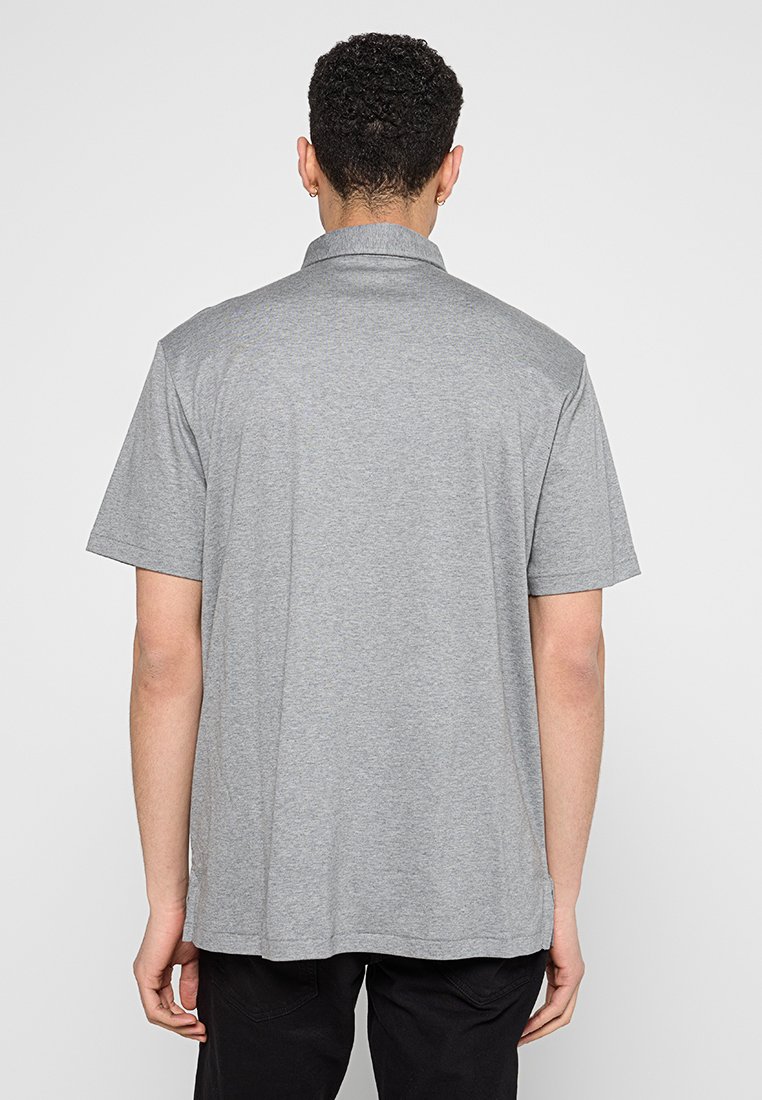Polo de manga corta gris hecho de una tela suave, con un collar clásico y un corte relajado, con sutiles detalles de costura en el dobladillo.