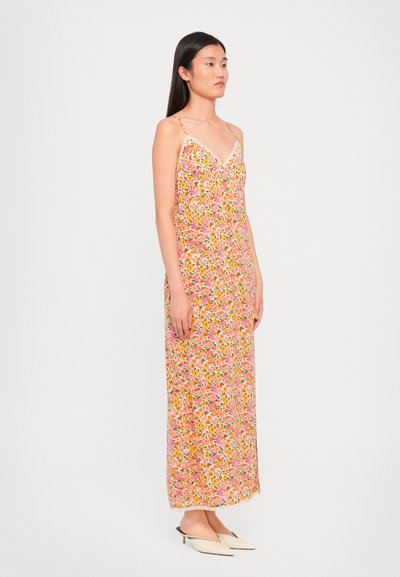 Vestido maxi floral con escote en v, con tirantes finos y un fondo rosa vibrante con patrones de flores multicolores. Textura de tela suave.