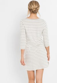 Abito a righe con scollo rotondo, maniche a tre quarti e una texture morbida. Il motivo consiste in righe alternate di grigio chiaro e bianco.