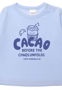 Helles blauer Baumwoll-Kindershirt mit grafischem Text "Cacao vor dem Chaos", begleitet von einer lächelnden Tasse und einer Kreuzung-Illustration.