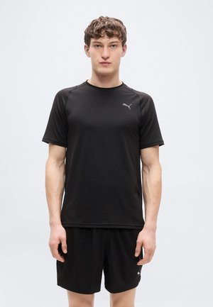 Zwart sportshirt met korte mouwen en ronde hals, met een klein grijs logo op de borst; gecombineerd met zwarte korte broek.