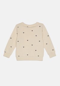 Sweatshirt beige avec des motifs de cœurs noirs, col rond, manches longues et poignets côtelés. Tissu doux avec une texture lisse.