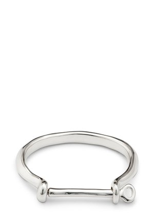 Pulsera de plata pulida con una banda curva y un cierre de barra horizontal que presenta un pequeño lazo en un extremo.