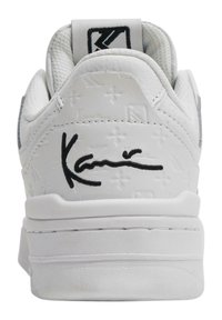 Baskets en cuir blanc avec des motifs embossés, un col rembourré et un détail noir signature sur le talon. Semelle texturée blanche pour une meilleure adhérence.