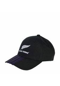 Gorra negra de algodón con visera curvada, que presenta un logo de helecho blanco y el texto "BLACK FERNS", con rayas moradas en la visera.