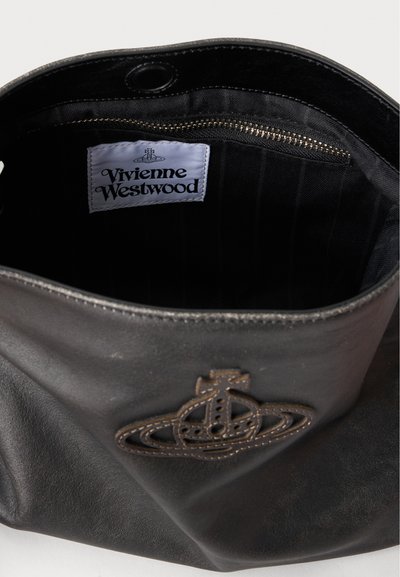 Μαύρη δερμάτινη τσάντα με το λογότυπο Vivienne Westwood μπροστά και λευκή ετικέτα μάρκας στο εσωτερικό κοντά σε τσέπη με φερμουάρ.