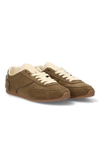 Zapatos deportivos de ante marrón con cordones color crema, de perfil bajo, punta redondeada y suela de goma. Diseño simple con detalles de costura mínimos.