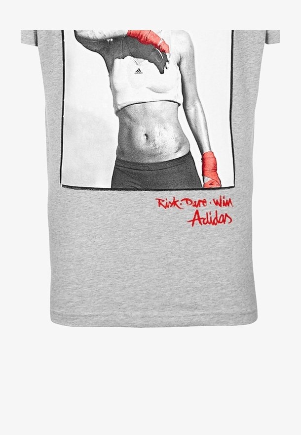 Camiseta de algodón gris con una impresión en blanco y negro de una persona con vendas de boxeo rojas. El texto en la parte inferior dice "Riesgo, Atrevimiento, Victoria" y "Adidas."