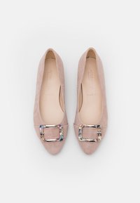Ballerines en suede rose avec un bout carré, présentant une boucle décorative aux accents multicolores. Doublure intérieure lisse, design bas.