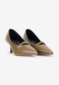 Chaussures à talons hauts en cuir kaki avec un bout pointu et un petit accent métallique décoratif au-dessus de l'arche, présentant une finition lisse.