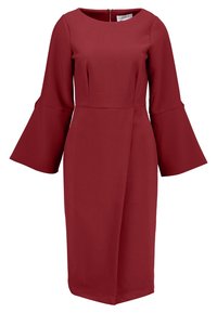 Rubiinipunainen mekko, joka on valmistettu teksturoidusta kankaasta. Siinä on pitkät kellohihat ja vartalonmyötäinen yläosa, jossa on takana vetoketjusulku.