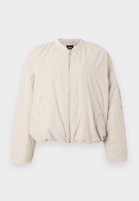 Světle béžová bomber bunda se zipem, žebrovaným límcem a elastickým pasem. Obsahuje boční kapsy a hladký texturovaný materiál.