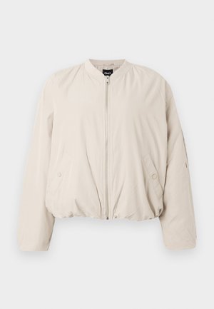 Jasno beżowa kurtka bomberka z zamkiem błyskawicznym, prążkowanym kołnierzem i elastycznym paskiem w talii. Posiada boczne kieszenie i gładką teksturę materiału.