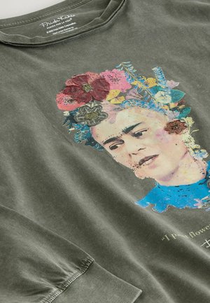 Olive green cotton t-shirt featuring a colorful printed portrait with flowers and a quote, rounded neckline, and long sleeves.
