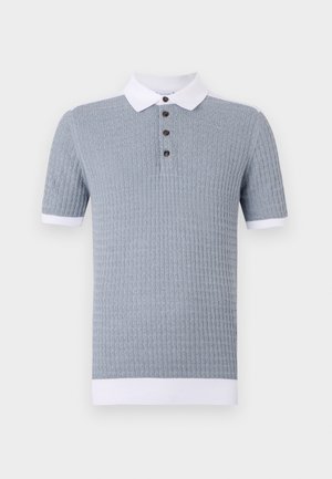 Heleda sinine lühikeste varukatega polo särk tekstuuriga mustriga, valge krae ja kolme pruuniga nööbiga. Üksik valge mansett varruka otstes.