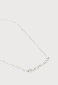 Λεπτό ασημένιο κολιέ με αλυσίδα και κεντρικό κομμάτι από κυρτή ασημένια μπάρα, διακοσμημένη με μικρά διάφανα κρύσταλλα σε λευκό φόντο.