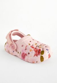Sabot rose à enfiler avec bride au talon, trous de ventilation et motif floral multicolore sur la tige et la semelle.