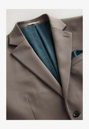 Brun kostymjacka med en mjuk textur, slagkrage och ett foder i teal med mönster, samt en accent med fickSquare. Svart knappdetalj synlig.