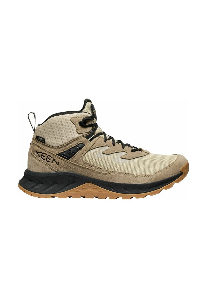 Beige Wanderschuh mit einem Obermaterial aus Mesh und Wildleder, schwarzen Akzenten, Schnürung, gepolstertem Zwischensohle und strukturiertem Gummiausgang.