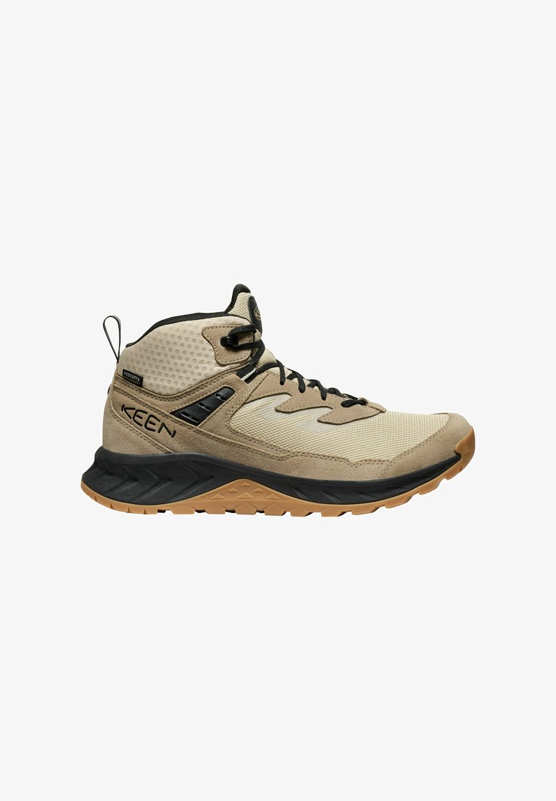 Beige Wanderschuh mit einem Obermaterial aus Mesh und Wildleder, schwarzen Akzenten, Schnürung, gepolstertem Zwischensohle und strukturiertem Gummiausgang.