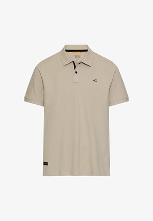 Beige kortærmet poloshirt med sort knapstykke, lille logo på brystet og mærke med branding nær kanten.