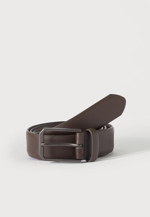 Cintura in pelle marrone scuro avvolta con fibbia rettangolare in metallo nero opaco su uno sfondo chiaro uniforme.