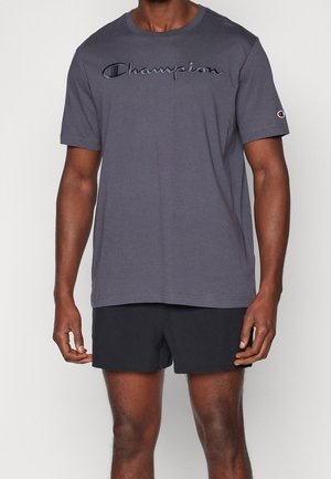 Grå bomulls t-shirt med korta ärmar och rund halsringning, med svart broderad "Champion" logotyp över bröstet.
