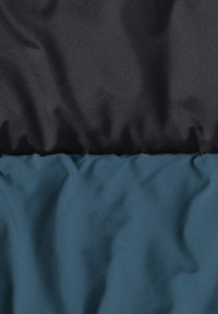 Polstret stoff i to seksjoner: toppen er glatt svart, bunnen er teksturert teal. Begge har en subtil glans, med myke folder.