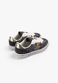 Zapatillas bajas con estampado de leopardo, cordones blancos, calaveras y tibias doradas en los laterales, y acentos metálicos dorados en los talones sobre suelas texturizadas.