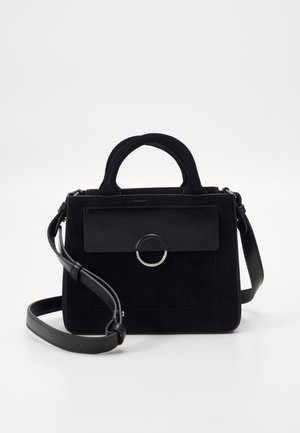 Sac à main noir en daim avec un rabat en cuir lisse et un matériel circulaire. Il dispose de poignées courtes et d'une bandoulière réglable.