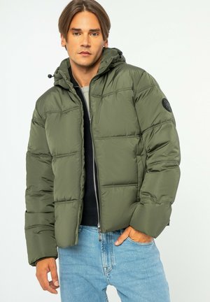 Olijfgroene gewatteerde jas met een capuchon, ritsluiting en zichtbare stiksels. Heeft een zwart logo-opdruk op de linker mouw.