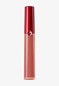 Flytende leppestift i en klar tube med en rød kork. Fargen er en myk nudefarget rosa. Har en metallisk logo foran.