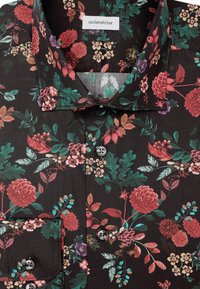 Camicia nera con motivo floreale multicolore che presenta fiori e foglie rossi, rosa, viola e verdi, frontale con bottoni e taschino sul petto.