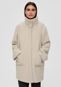 Beige wollenblend jas met een hoge kraag, zijzakken en een rechte snit. Geweven, zachte stof met een subtiel patroon.