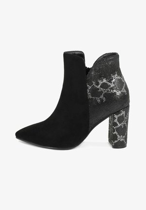 Schwarze Knöchelboots mit spitzer Zehe, aus einer Kombination aus Wildleder und strukturiertem, gemustertem Material. Klobiger, dekorativer Absatz.