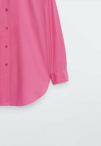 Roze overhemd met knopen, gemaakt van gladde stof, met een klassieke kraag, lange mouwen en een afgeronde zoom; minimale details en een eenvoudige stijl.