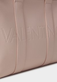 Roza usnjena torba z embosiranim logotipom "VALENTINO", gladka tekstura, kontrastno šivanje in trdne naramnice.