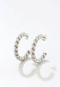 Orecchini a cerchio in argento attorcigliato con un design testurizzato e intrecciato. Hanno una superficie lucida e una chiusura a vite per un indossamento sicuro.