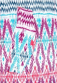 Bunt gemusterter Stoff mit geometrischen Designs in Blau, Rosa und Weiß. Eine kleine Tasche mit einem roten Knopf-Akzent ist sichtbar.